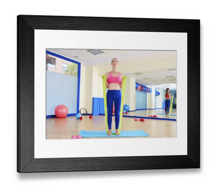 Framed Print : Pilates woman biceps rubber band exercise workout at gym indoor Framed Print : Pilates woman biceps rubber band exercise workout at gym indoor