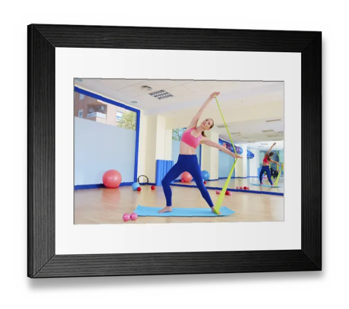 Framed Print : Pilates woman standing rubber band exercise workout at gym indoor