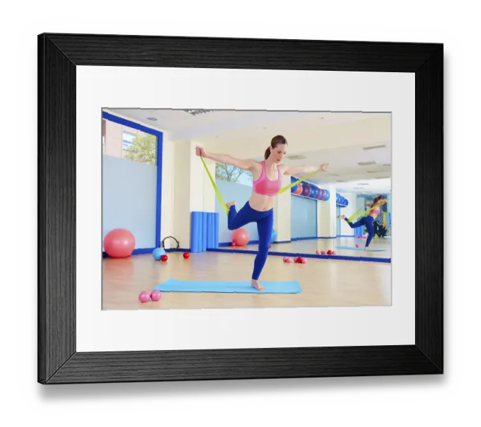 Framed Print : Pilates woman standing rubber band exercise workout at gym indoor