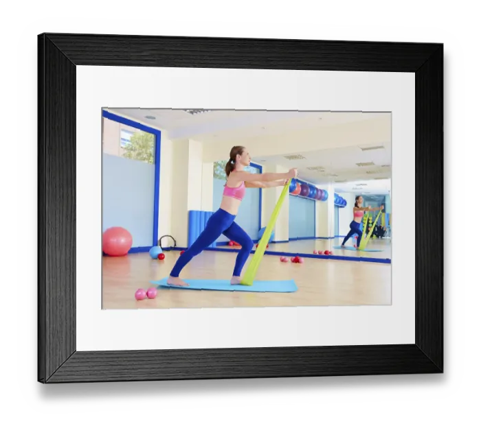Framed Print : Pilates woman standing rubber band exercise workout at gym indoor