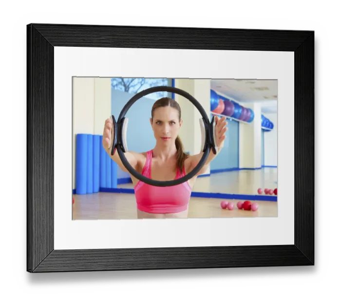 Framed Print : Pilates woman magic ring hands exercise workout at gym indoor