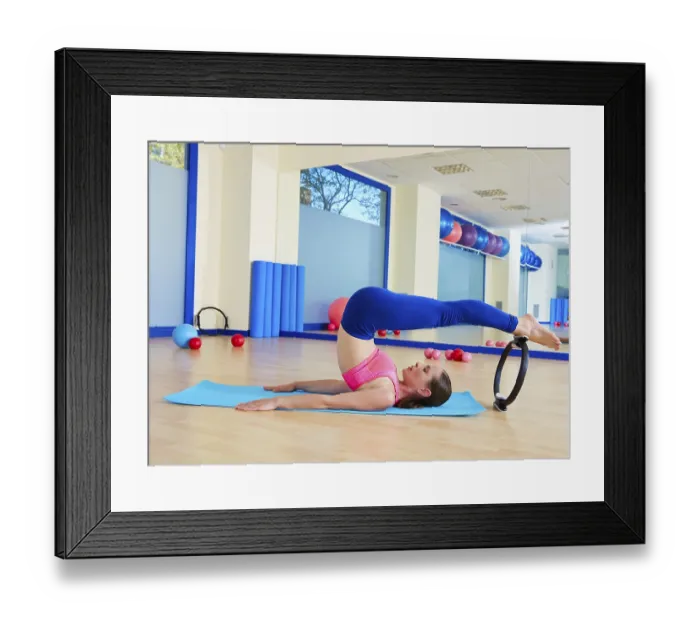 Framed Print : Pilates woman roll over magic ring exercise workout at gym indoor