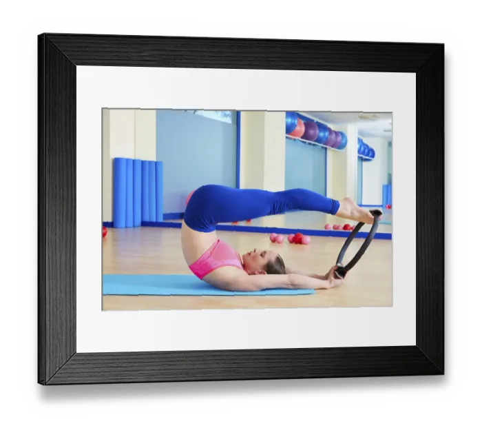 Framed Print : Pilates woman roll over magic ring exercise workout at gym indoor