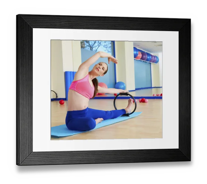 Framed Print : Pilates woman side stretch magic ring exercise workout at gym indoor