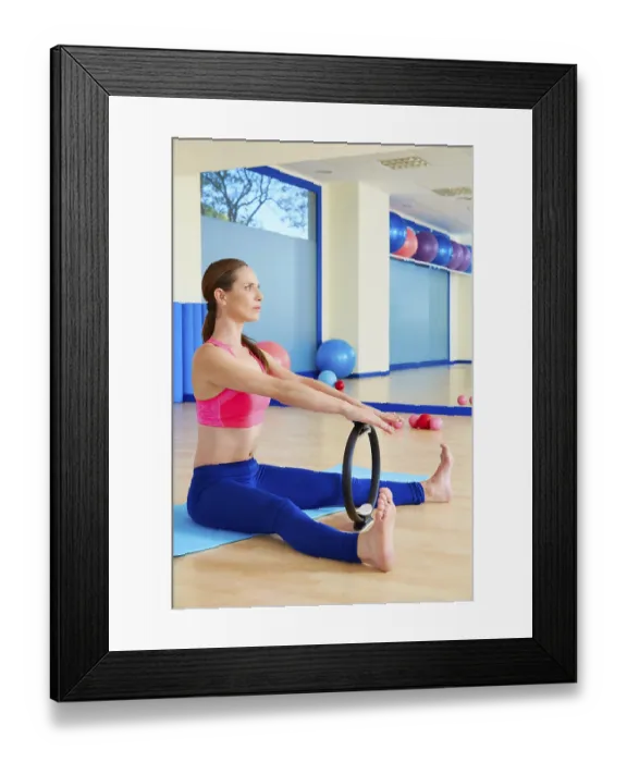 Framed Print : Pilates woman spine stretch forward magic ring exercise workout at gym indoor