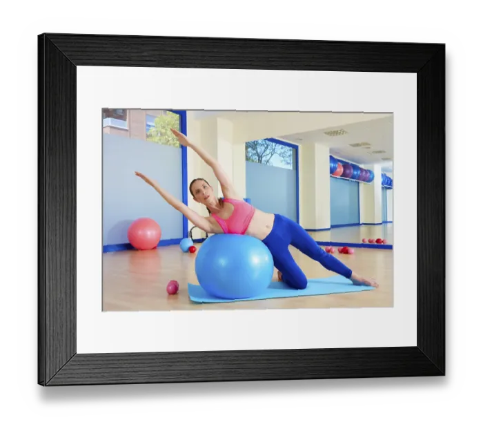 Framed Print : Pilates woman side bend fitball exercise workout at gym indoor swiss ball