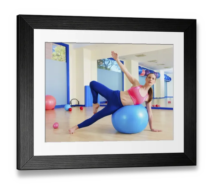 Framed Print : Pilates woman passes fitball exercise workout at gym indoor swiss ball Framed Print : Pilates woman passes fitball exercise workout at gym indoor swiss ball