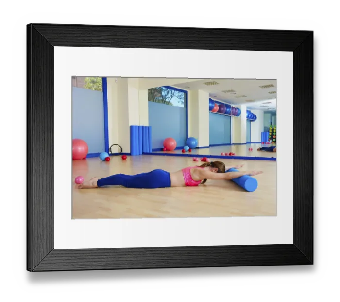 Framed Print : Pilates woman roller swan roll exercise workout at gym indoor