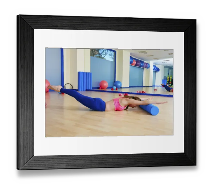 Framed Print : Pilates woman roller swan dive roll exercise workout at gym indoor