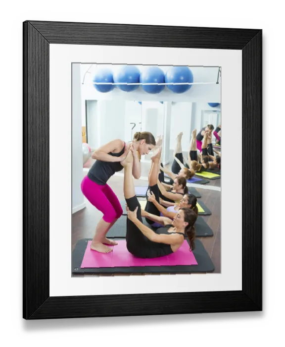 Framed Print : Aerobics Pilates personal trainer helping women group in a gym class