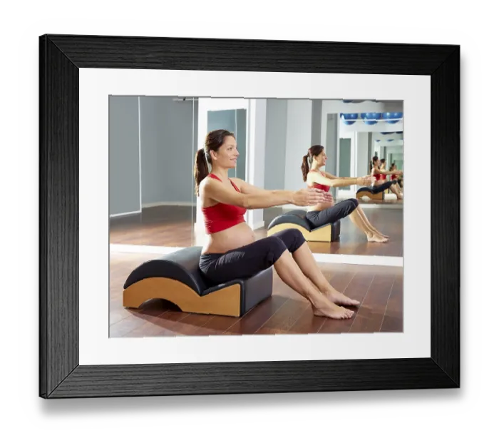 Framed Print : Pregnant woman pilates exercise with spine wave corrector