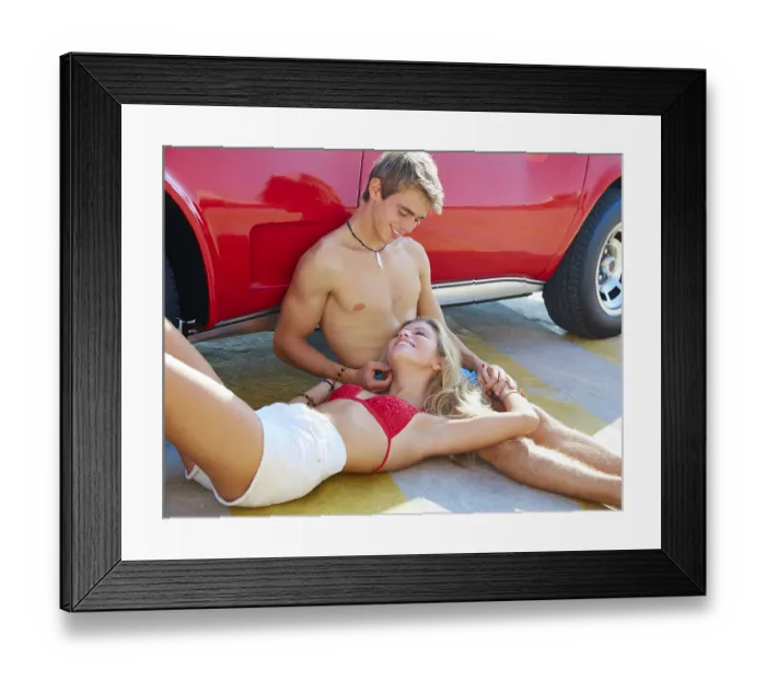 Framed Print : Happy young couple relaxed in a car side sitting on the floor