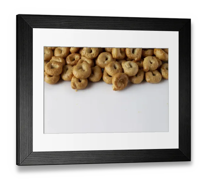 Framed Print : Salty tarallini cookies scattered on a white background