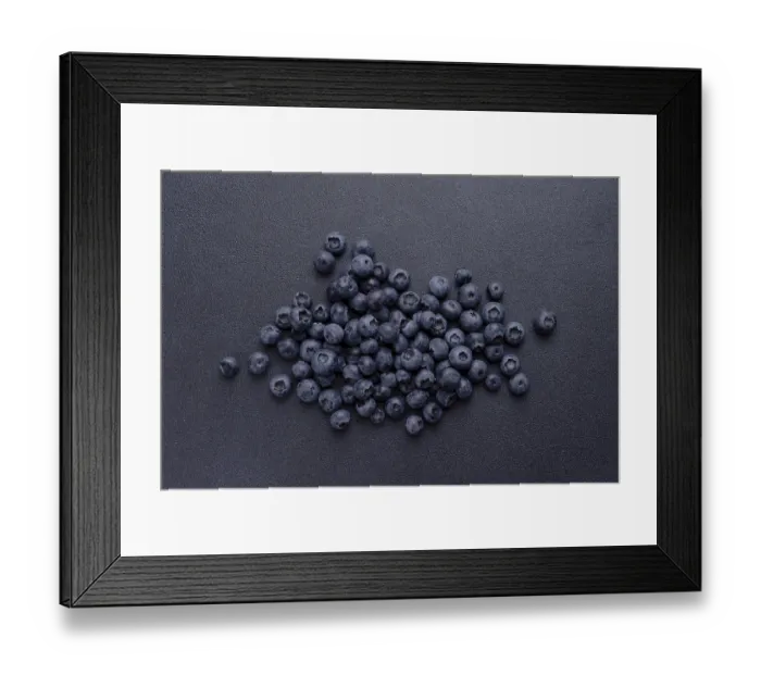 Framed Print : Blueberries are scattered on a blue background