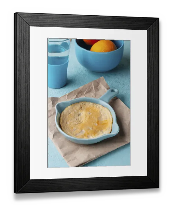 Framed Print : Yellow omelette in a blue frying pan, on the table Framed Print : Yellow omelette in a blue frying pan, on the table