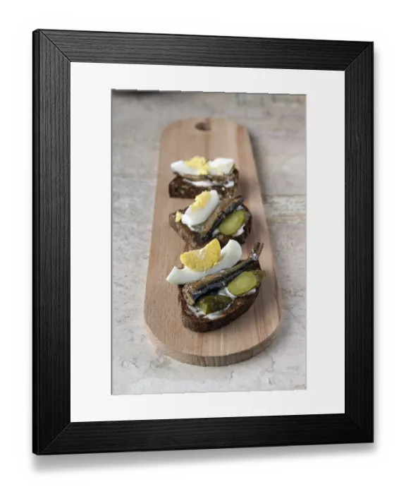 Framed Print : Sandwiches with sardines on a long wooden board