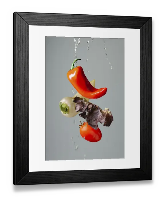 Framed Print : Vegetables in splashes of water flying on a gray background