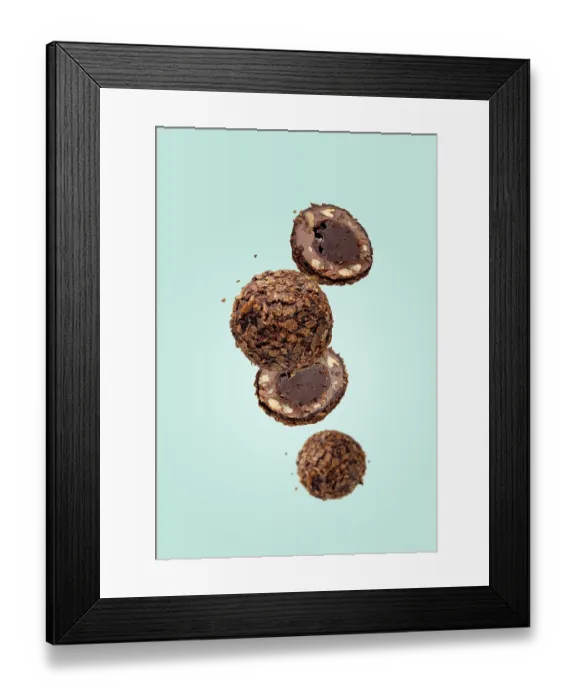 Framed Print : Round chocolates flying on a blue background