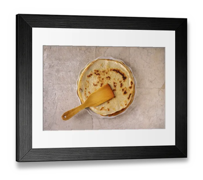 Framed Print : Pancakes and a wooden spatula lie on a round ceramic plate on a beige background