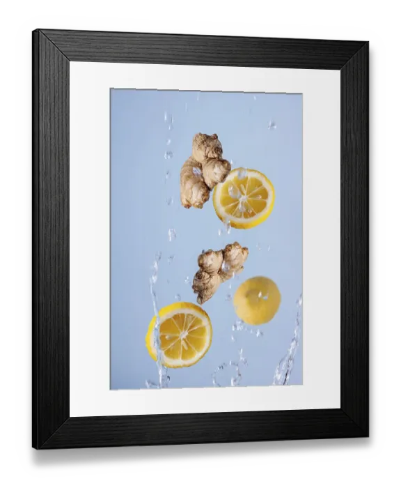 Framed Print : Slices of lemon, ginger in splashes of water fly on a blue background