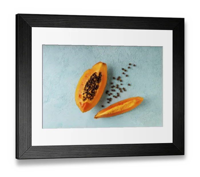Framed Print : Papaya slices lie on a blue background, copy space