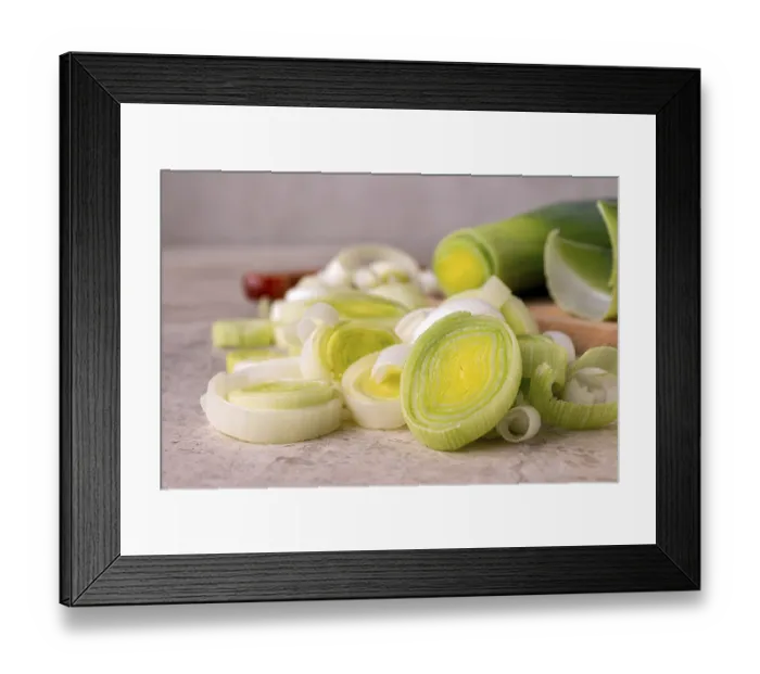 Framed Print : Leek cut into slices on a wooden board