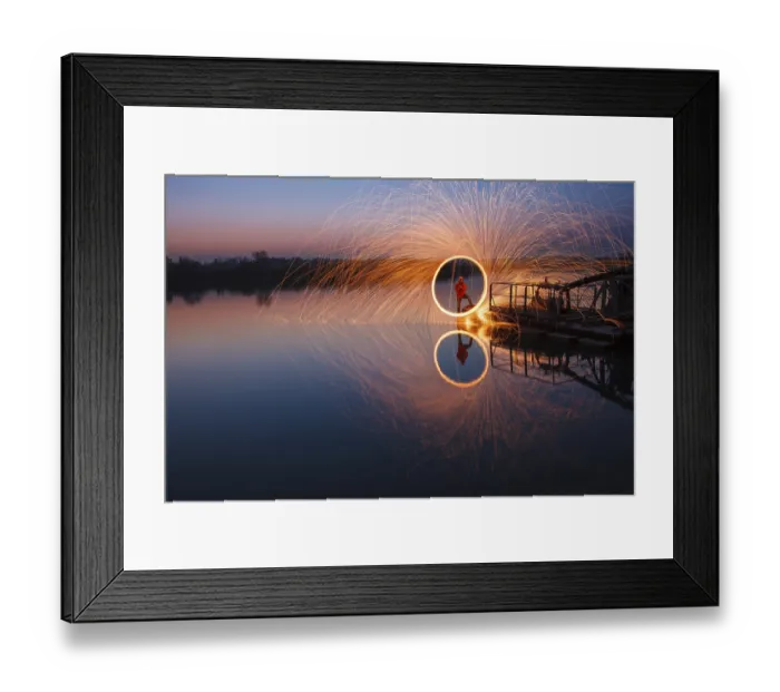 Framed Print : Man creates circle of light from steel wool over lake at night with reflection