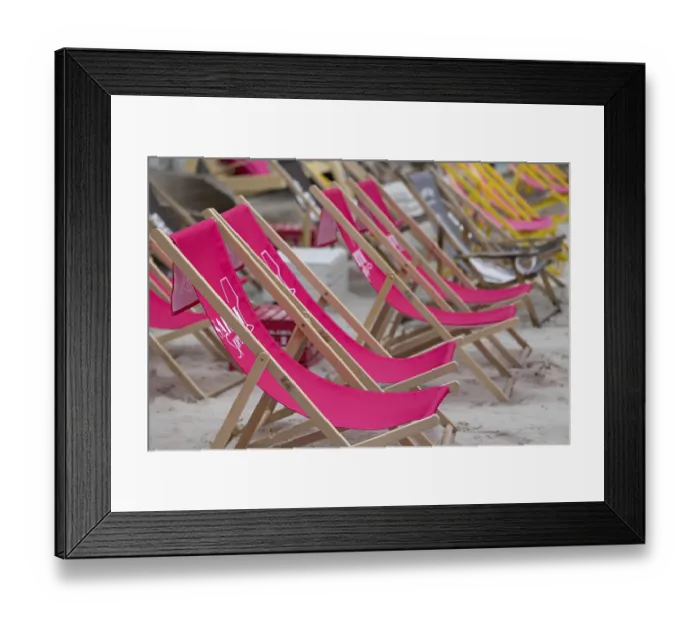 Framed Print : Pink deckchairs are set up on the beach and convey a summery feeling Framed Print : Pink deckchairs are set up on the beach and convey a summery feeling