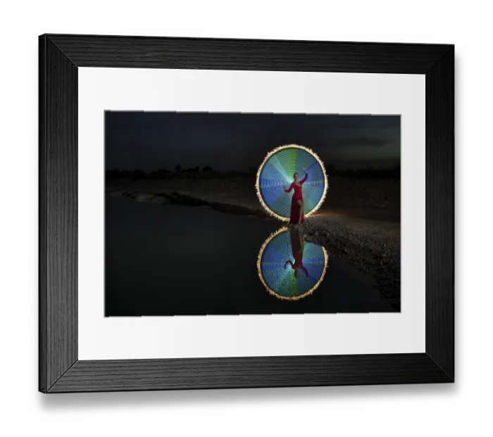 Framed Print : Woman in red dress, performs in elegant pose a colourful light painting with reflection at a lake Framed Print : Woman in red dress, performs in elegant pose a colourful light painting with reflection at a lake