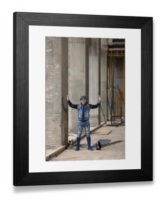 Framed Print : Man in modern jeans clothing with hat posing on a construction site between columns
