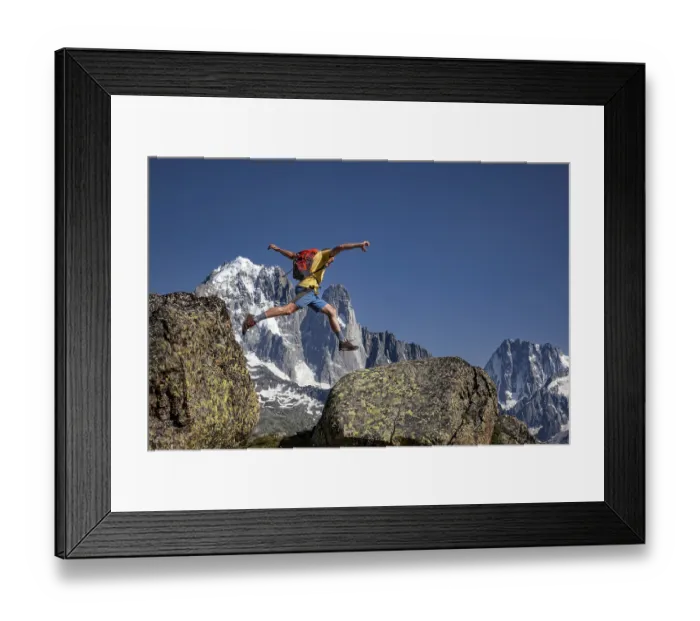 Framed Print : Sporty jump between two rocks against an impressive mountain backdrop Framed Print : Sporty jump between two rocks against an impressive mountain backdrop