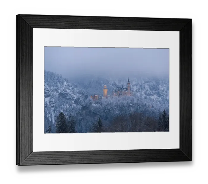 Framed Print : Castle rises above a quiet, snow-covered winter landscape under a misty sky