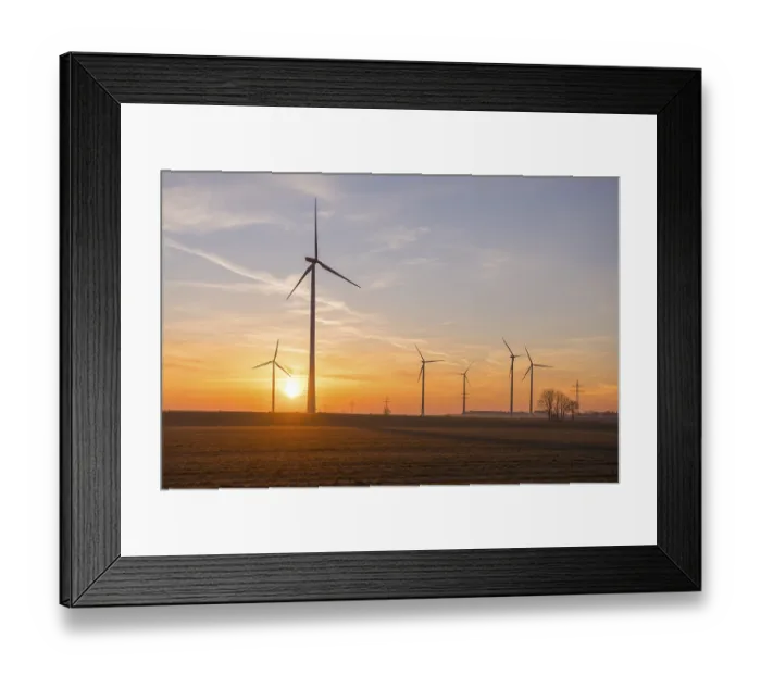 Framed Print : Wind turbines over open fields at sunset