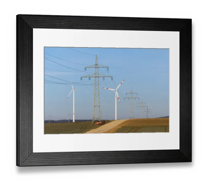 Framed Print : A mix of power lines and wind turbines crosses a country road in a rural setting Framed Print : A mix of power lines and wind turbines crosses a country road in a rural setting