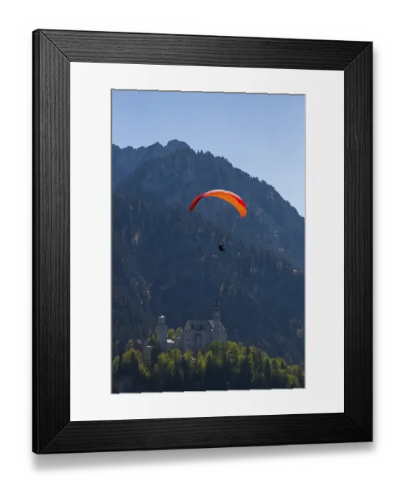Framed Print : Paraglider over Neuschwanstein Castle in the middle of a natural mountain landscape