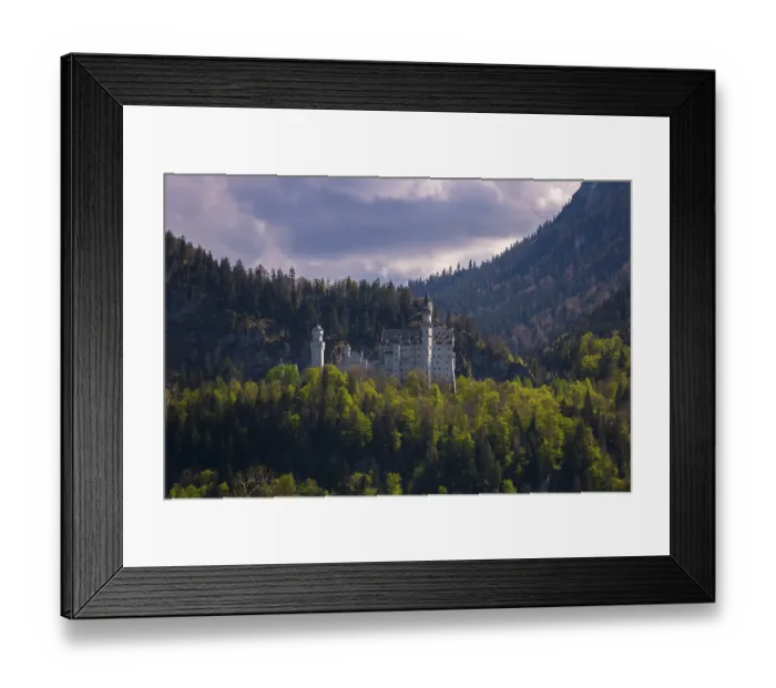 Framed Print : Neuschwanstein Castle against a backdrop of forest and mountains