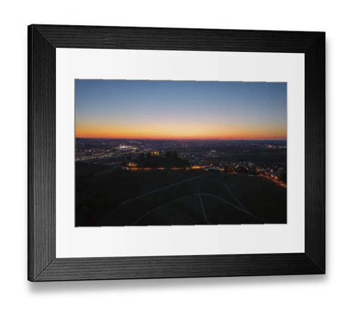 Framed Print : Expansive city view at dusk, with illuminated chapel and vineyards