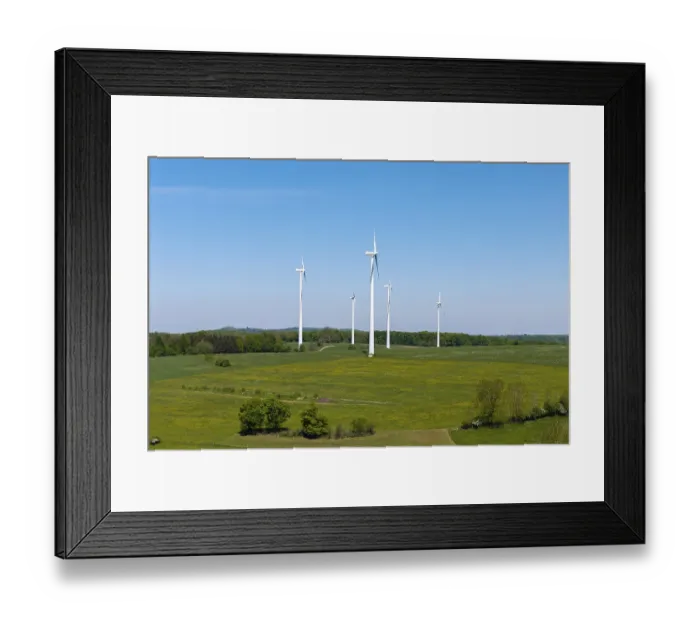 Framed Print : Wind turbines stand on a green area