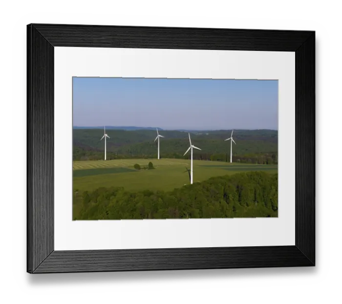 Framed Print : Landscape with wind turbines and green fields under a blue sky