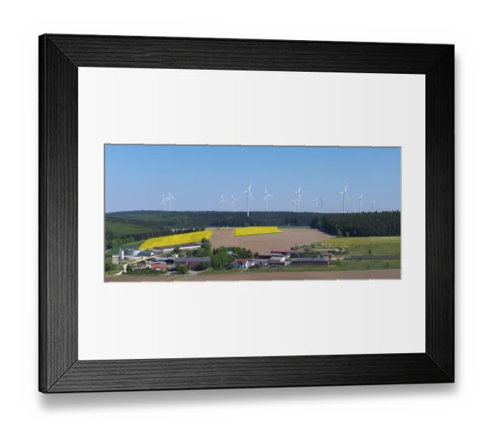 Framed Print : Landscape with wind turbines above agricultural fields and farms in front of a blue sky