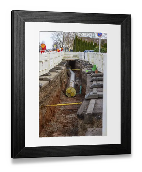 Framed Print : Construction trench with installed district heating pipes and barriers in an urban area