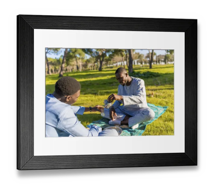 Framed Print : Two senegalese men in traditional clothing are sitting on a prayer rug in a park