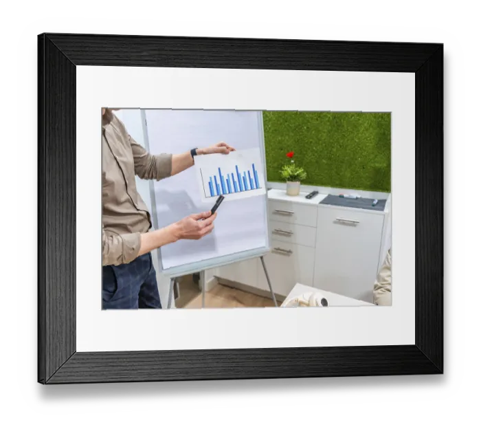 Framed Print : Businessman presenting bar chart on paper during a meeting in a modern coworking office with green wall