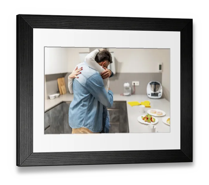 Framed Print : Romantic couple embracing in a cozy kitchen