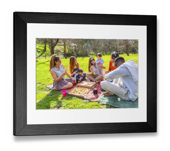 Framed Print : Group of friends and their children having fun at a picnic in a park