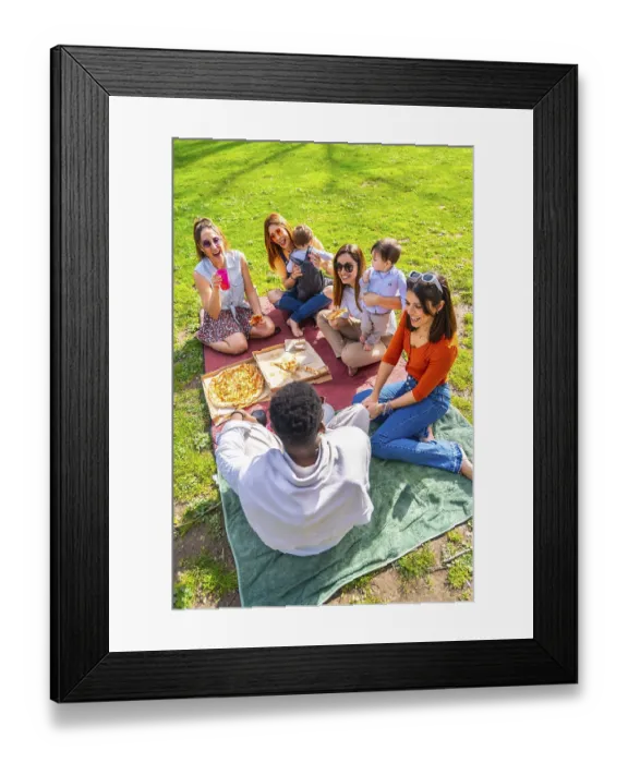 Framed Print : Friends and their babies are sharing pizza and drinks during a cheerful picnic in a park