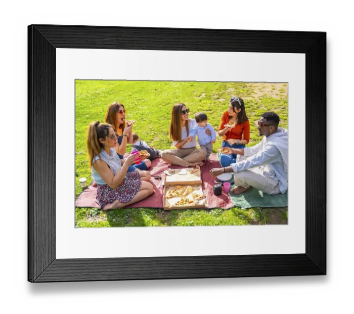 Framed Print : Friends and family sharing pizza and drinks at a sunny park picnic