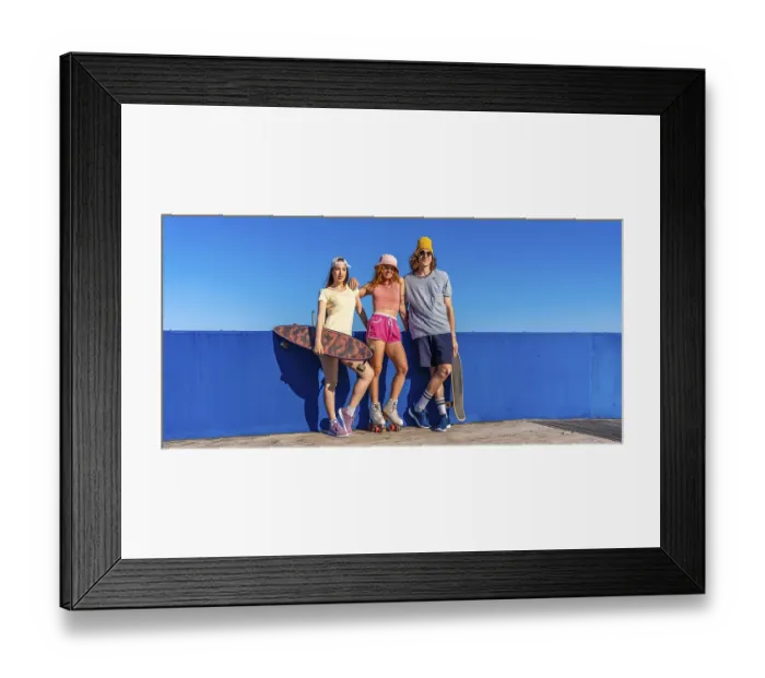 Framed Print : Three cool skaters enjoying a sunny day by a vibrant blue wall