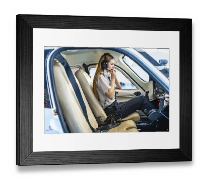 Framed Print : Female pilot sitting in the cockpit of a small aircraft