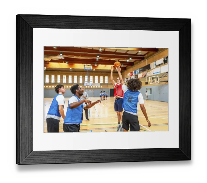 Framed Print : Basketball players practicing shooting and defending during training session on a basketball court Framed Print : Basketball players practicing shooting and defending during training session on a basketball court